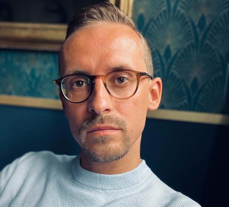 Porträt eines Mannes mit Brille, und einem nachdenklichen Ausdruck. Christopher Keilich Inhaber der Praxis HOLERYA